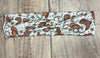 Western Texas Turban Twist Headband with brown cowboy boots hat and ropes on a light tan  background