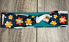 Navy background with happy daisy smiles with hippie flowers with a teal mositure wicking fabric underneath