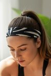 Woman wearing a tan and Black yoga headband