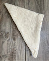 Cream-colored handmade workout headband with subtle embroidered floral patterns on wooden surface