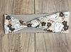 White Ghosts with black flowers on a light brown background with tan moisture wicking undereneath