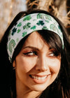 Woman wearing a green headband with shamrock and rainbow pattern