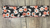 Dark background with pink and white daisy's with white ghosts scattered throughout with pink moisture wicking underneath