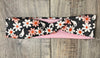 Dark background with pink and white daisy's with white ghosts scattered throughout with pink moisture wicking underneath