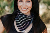 Smiling woman wearing a striped workout headband outdoors with green foliage background