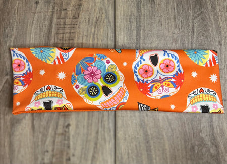 Sugar Skull with pink blue yellow and orange flowers on an orange background with moisture wicking underneath