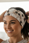 Woman in gray and white ghosts' fitness headband with black and brown flowers scattered throughout