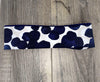 Athena Fitness handmade workout headband with navy blue and white abstract pattern on wood background