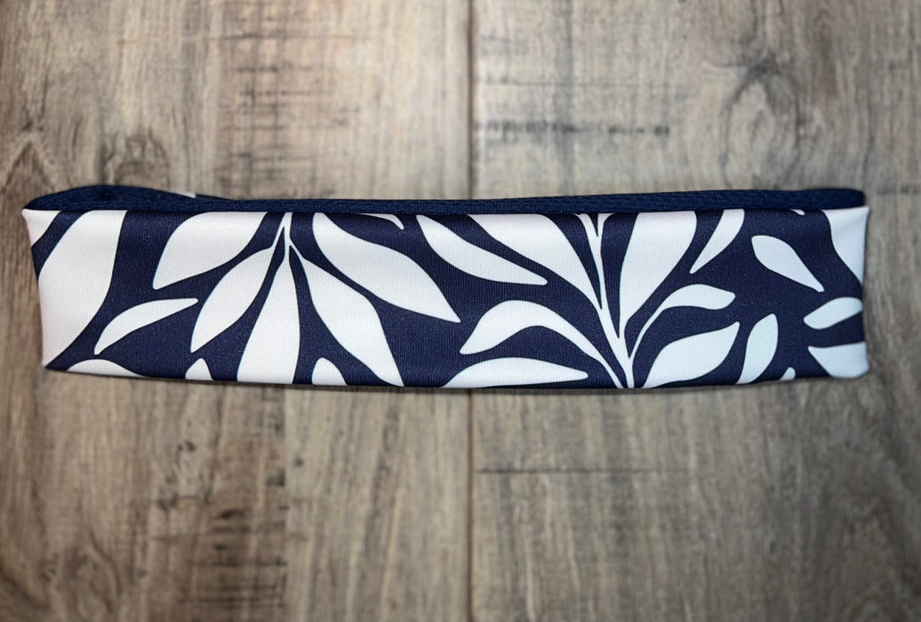 Handmade nonslip workout headband with navy blue and white leaf pattern on wooden surface