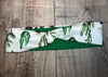 Handmade workout headband with green cactus print and solid green fabric on wooden surface