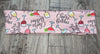 Pink workout headband with Cheers Bitches text and colorful cocktail glass illustrations on wood floor