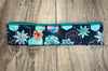 Athena Fitness moisture wicking workout headband with blue and orange succulent floral pattern on wooden surface