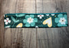 Handmade workout headband with green background, floral and heart patterns on wooden surface