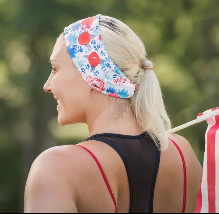 Woman in a floral handmade workout headband with blonde ponytail and black athletic top outdoors
