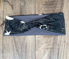 Black and gray workout headband with white celestial star and sunburst pattern on wooden background
