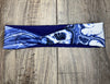 Handmade workout headband with blue and white tie-dye pattern on wooden background