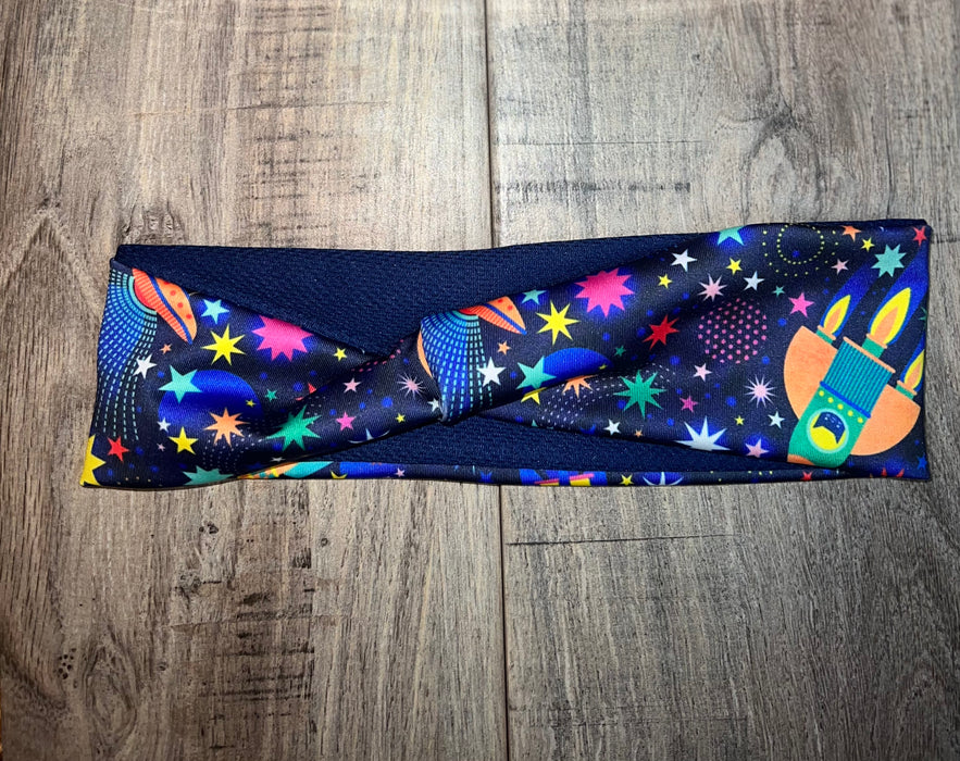 Athena Fitness stylish workout headband with colorful space and star print on wooden background