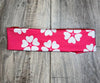 Pink workout headband with white heart-shaped flower patterns on wooden surface, Athena Fitness Collections