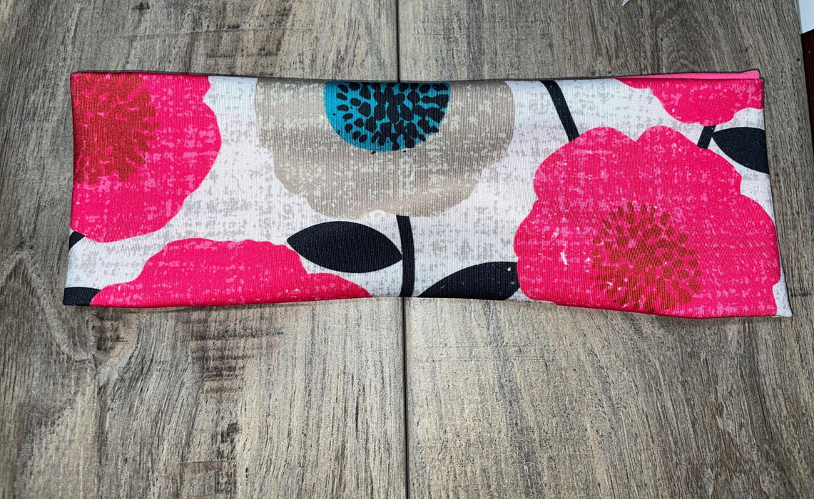 Athena Fitness floral workout headband with pink and beige flowers on wood background