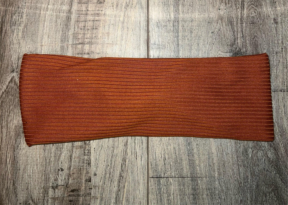 Handmade rust-colored ribbed workout headband on light wooden floor, Athena Fitness Collections