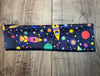 Colorful space-themed workout headband with rockets, stars, and planets on wooden floor