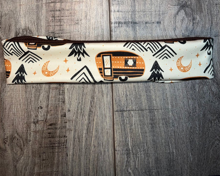 Handmade Vanlife workout headband with camping trailer, moon, and mountain print on wood background