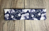 Athena Fitness handmade workout headband with navy blue and white floral pattern on wooden surface