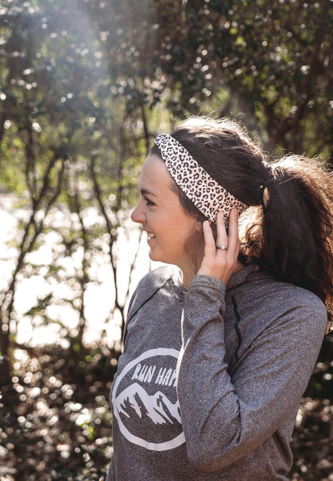 Cheetah Workout Headband with brown and black cheetah paw prints on a light brown fabric