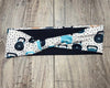 Close-up of a handmade fitness headband with a kettlebell print in black, blue, and white on a wooden floor